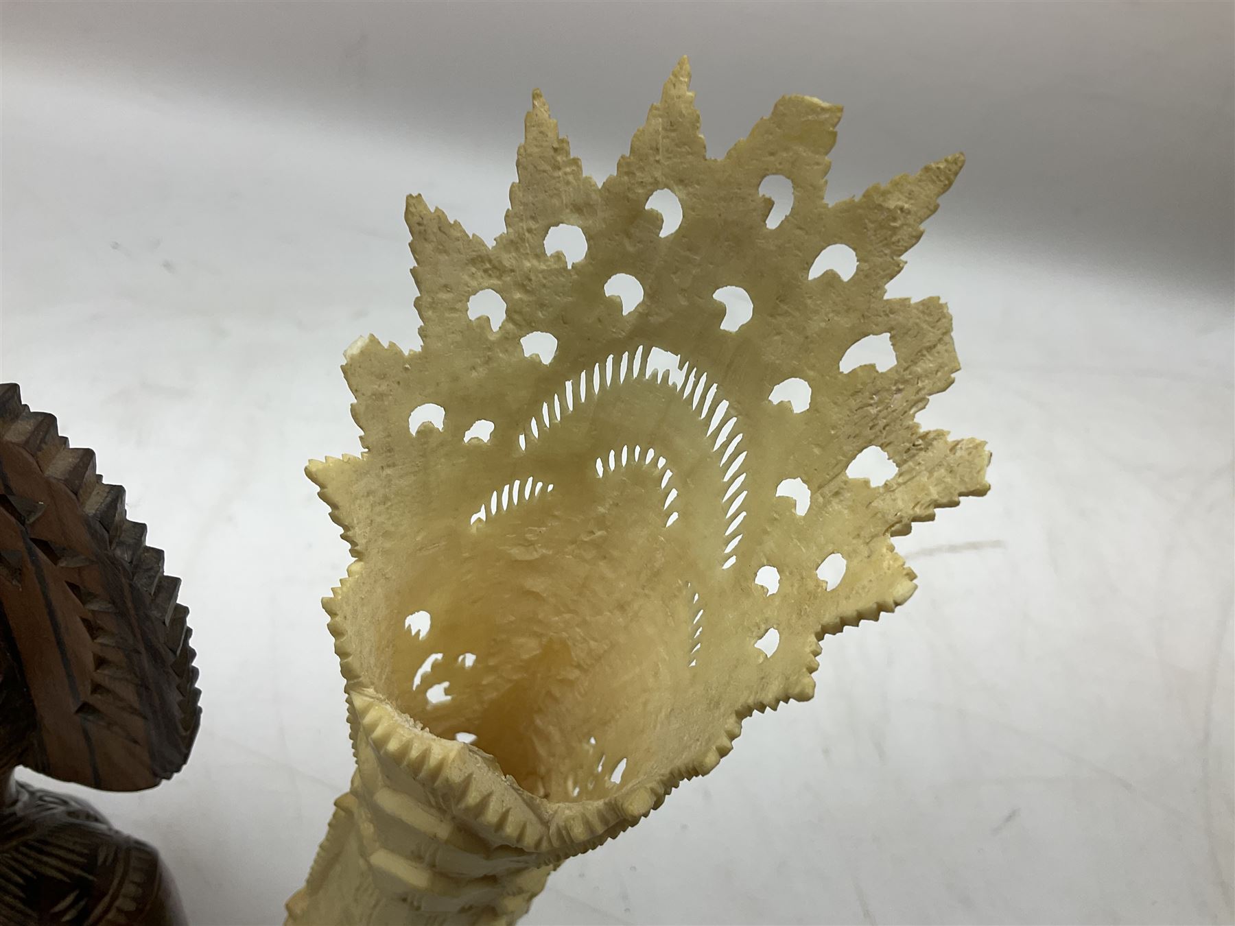 Hardwood bust of an Indoniesian Goddess, carved wearing a pierced headdress, from Klungkung, Bali, H20cm, together with a pair of bone carvings of deity figures, and a carved wood Netsuke in the form of a Chinese dragon