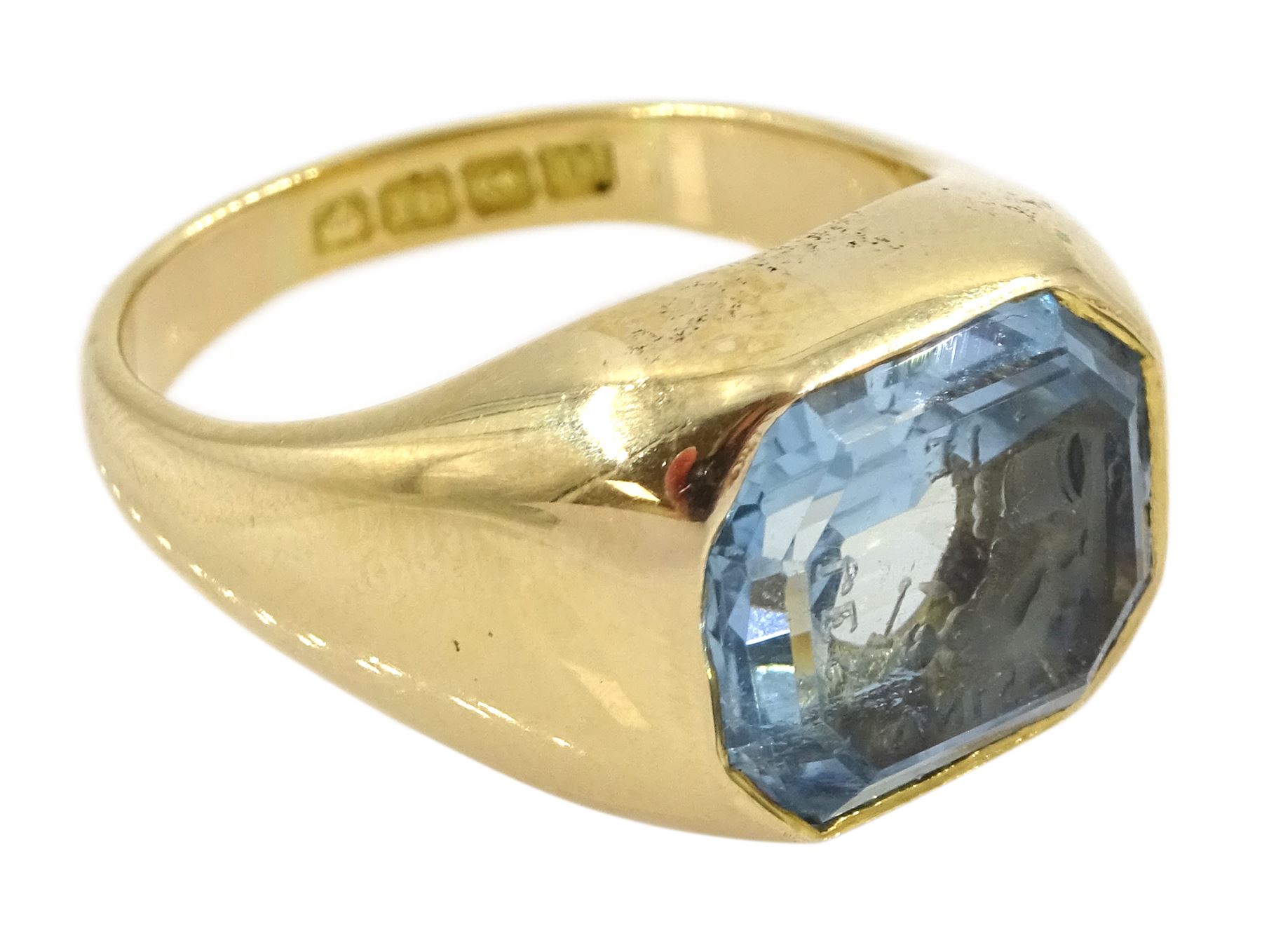 Early 20th century 18ct gold bezel set octagonal cut aquamarine intaglio ring, with Cupid as a blacksmith forging two hearts, Birmingham 1919