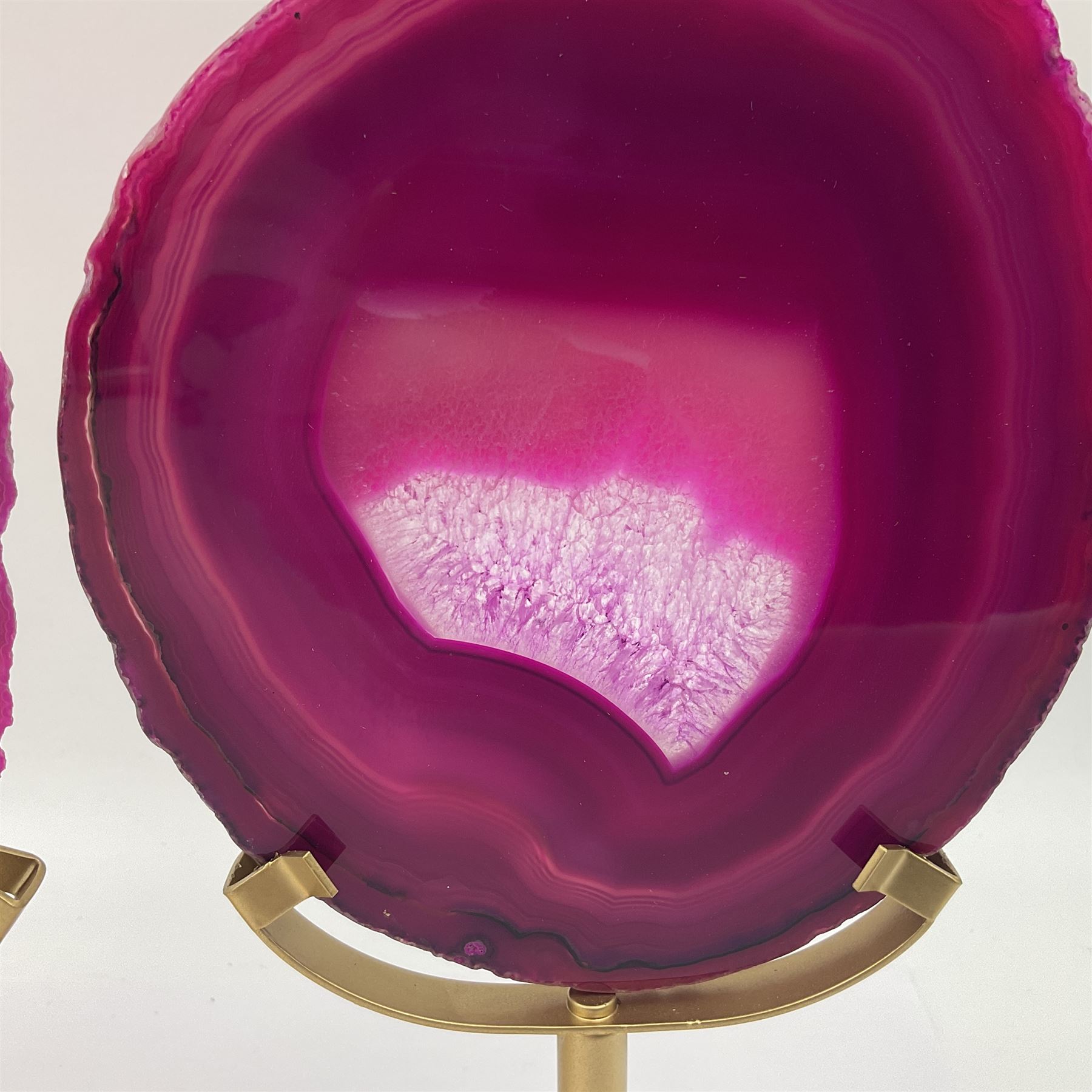 Pair of pink agate slices, polished with rough edges raised upon gilt metal stands, H20cm