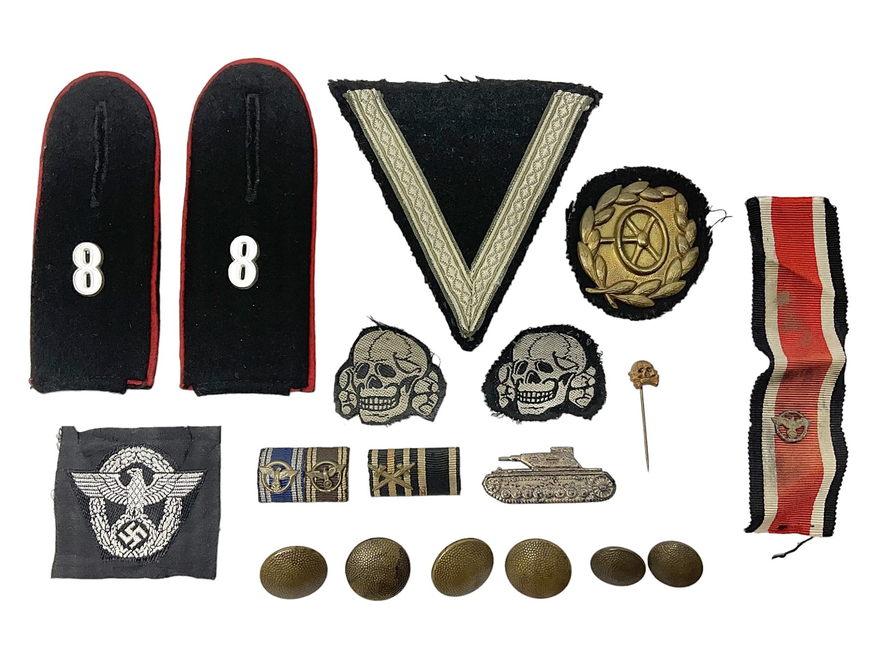 Collection of eleven German metal and cloth badges and uniform buttons including driver's badge, two 'SS' fabric skulls, private's shoulder tabs, Police cloth badge, tank destruction badge, medal bars and ribbon etc; most WW2 period