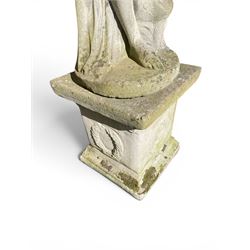 Cast stone garden figure of a classically draped nude female inspired by Aphrodite statues, with stylised up-do arranging her chitin on a circular base, the rectangular pedestal with egg-and-dart moulding over a floral wreath, in weathered finish