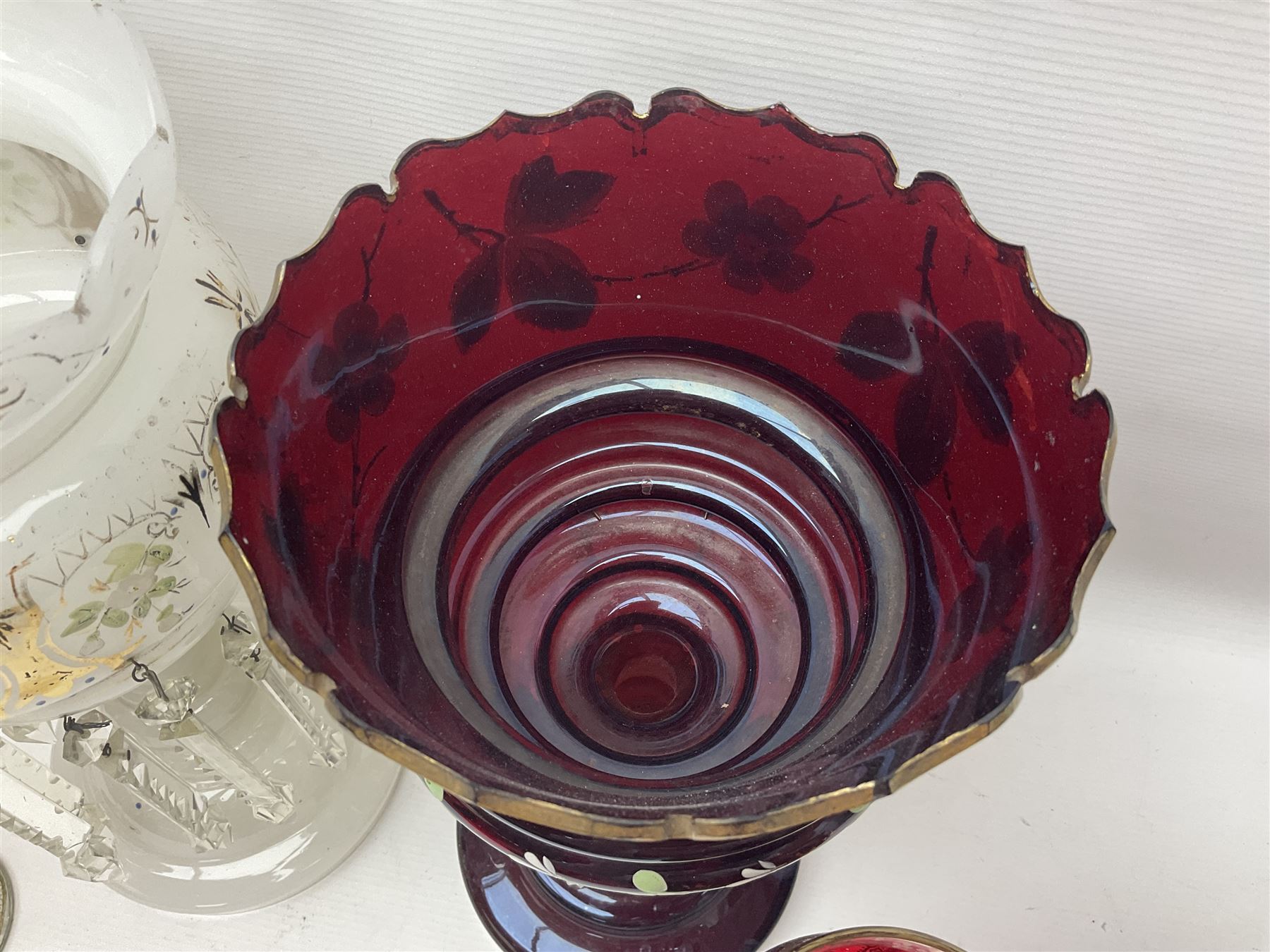 Bohemian red glass lustre, painted with stylised floral and foliate decoration, together with a milk glass example and two bohemian goblets converted to lustres 