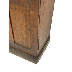 The North of England School Furnishing Company Limited Darlington - early 20th century oak school cupboard, projecting moulded cornice over two panelled doors, fitted with shelves, on chamfered plinth base 