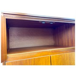 William Lawrence - mid-20th century teak double wardrobe, upper storage section over twin doors featuring recessed handles and contrasting horizontal panel, enclosing a hanging rail compartment, on plinth base with concealed castors