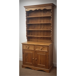  Pine kitchen dresser, projecting cornice, four plate racks, two drawers above two cupboard doors, shaped plinth, W92cm, H198cm, D50cm  
