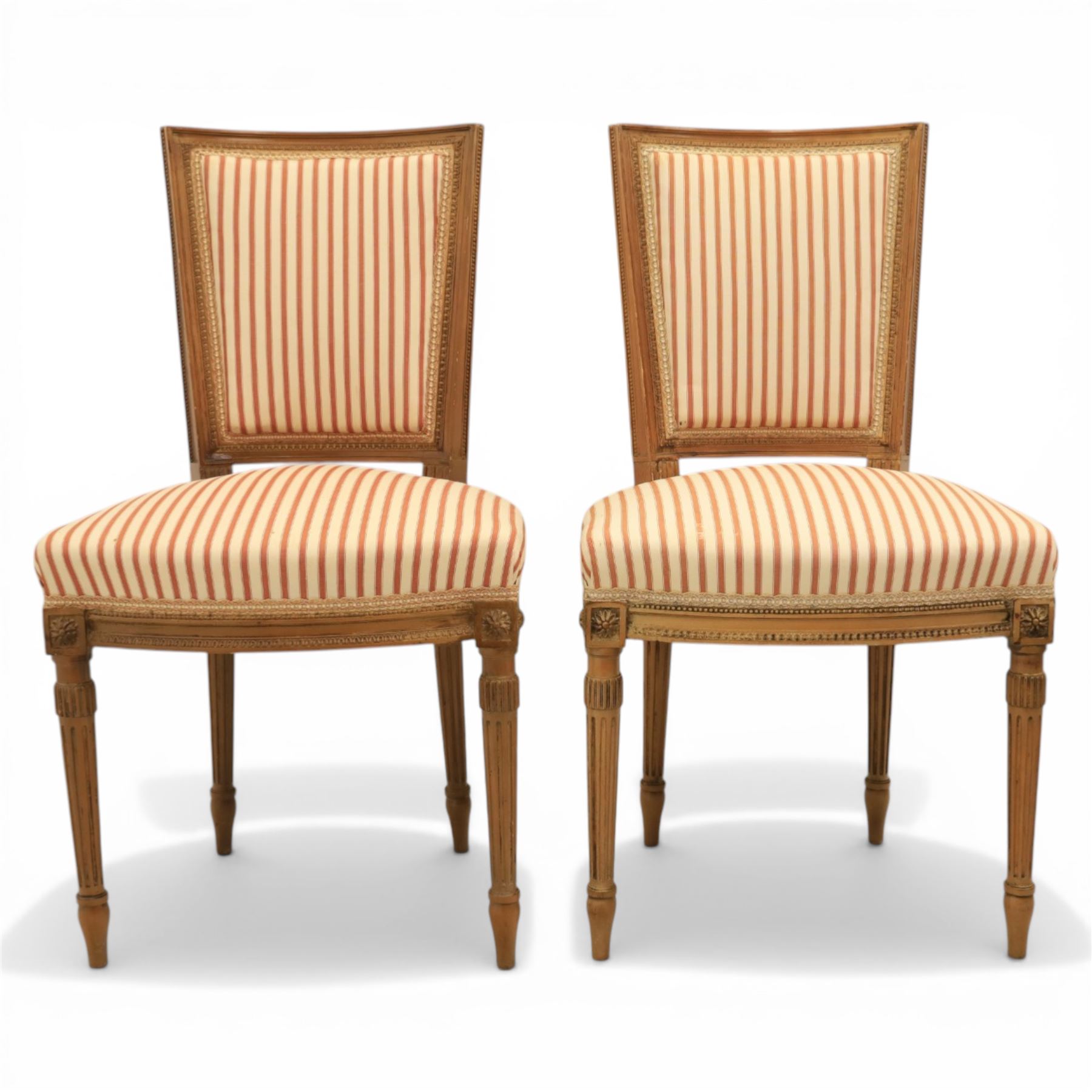 20th century Louis XVI style beech salon suite, comprising settee and four chairs, the settee with shaped rectangular back and upholstered arms over a shaped seat, the chairs with rectangular backs and overstuffed seats, each upholstered in striped fabric with close-nailed borders, upon fluted tapering supports headed by carved paterae, terminating in toupie feet, chairs H89cm W47cm