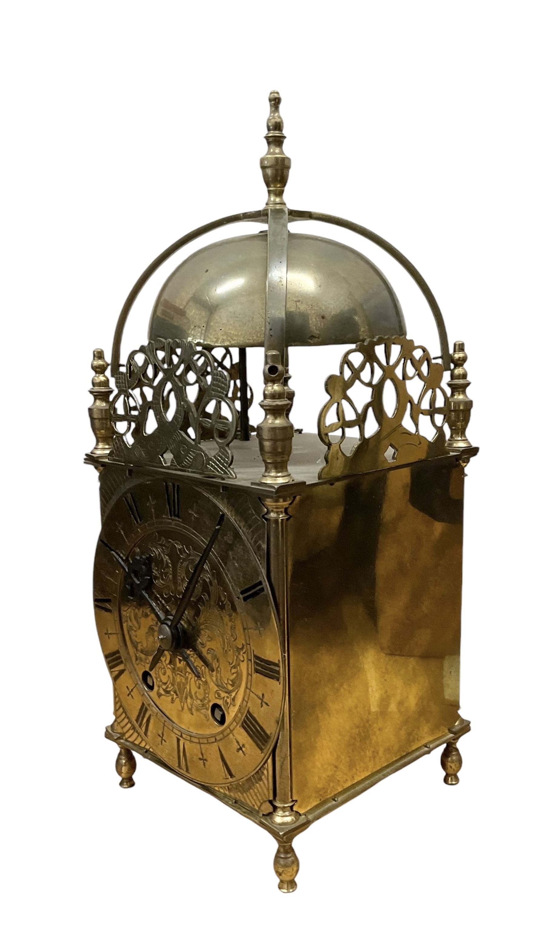 English - 20th century 8-day lantern clock in period 18th century style, square brass case surmounted by a domed bell, with a brass chapter, engraved dial centre and stylised period steel hands, with a two train spring driven movement striking the hours and half hours on a bell. With pendulum. 