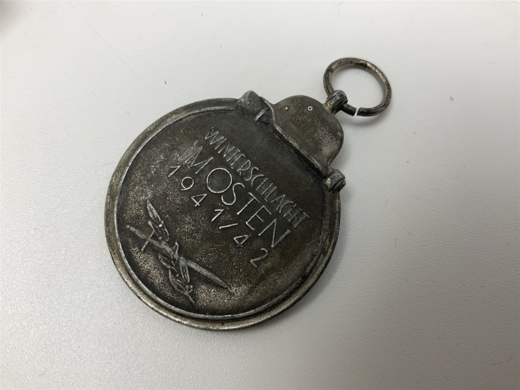 Four German awards - pre-WW2 two-position button hole ribbon for 1914 Iron Cross; WW1 wound badge open back cut-out version with silvered finish; miniature version Mother's Cross with ribbon bow; and The Eastern Medal, officially the Winter Battle in the East 1941–42 Medal (4)