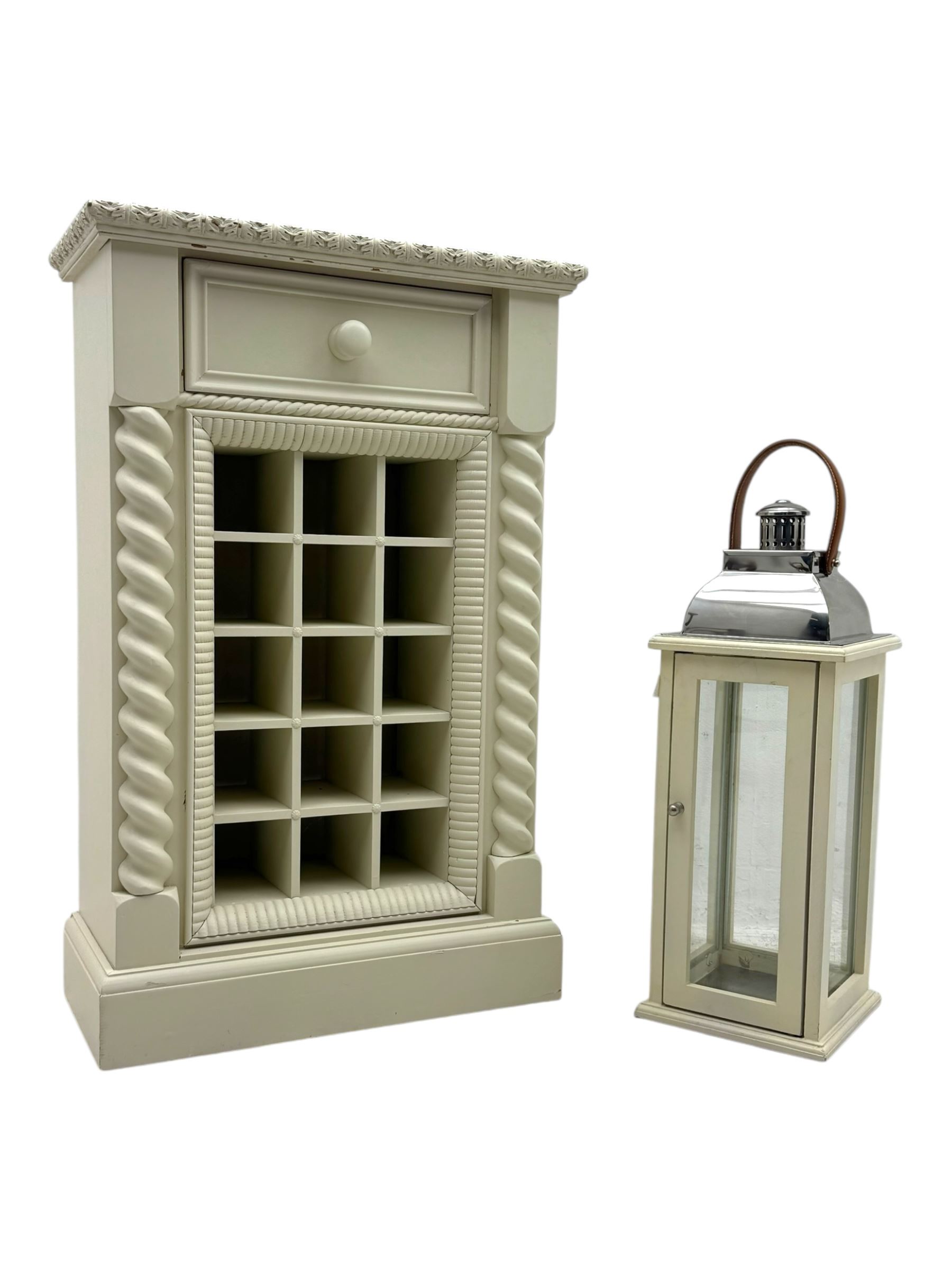 Contemporary painted wooden wine cabinet, rectangular form with carved leaf moulded cornice over single drawer and fifteen bottle compartments, flanked by spiral twist pilasters; together with a cream painted and chrome lantern, with glazed sides and leather handle (2)