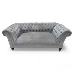 Early 20th century Chesterfield drop-arm two-seat settee, traditional shape with rolled arms and back, upholstered in buttoned pale blue fabric, on ogee block feet with brass castors 