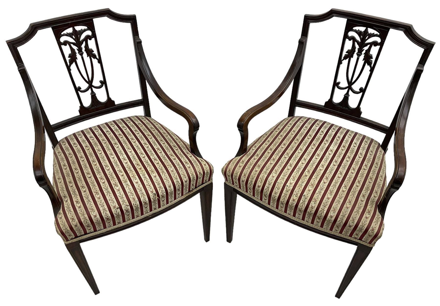 Edwardian mahogany framed three-piece salon suite - two-seat sofa, stepped cresting rail over acanthus and scroll carved pierced splat, upholstered in striped fabric (W124cm, H87cm, D62cm); and a pair of matching armchairs (W60cm) 