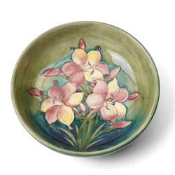 William Moorcroft African Lily pattern bowl, on a green ground, blue signature mark to base, D22cm