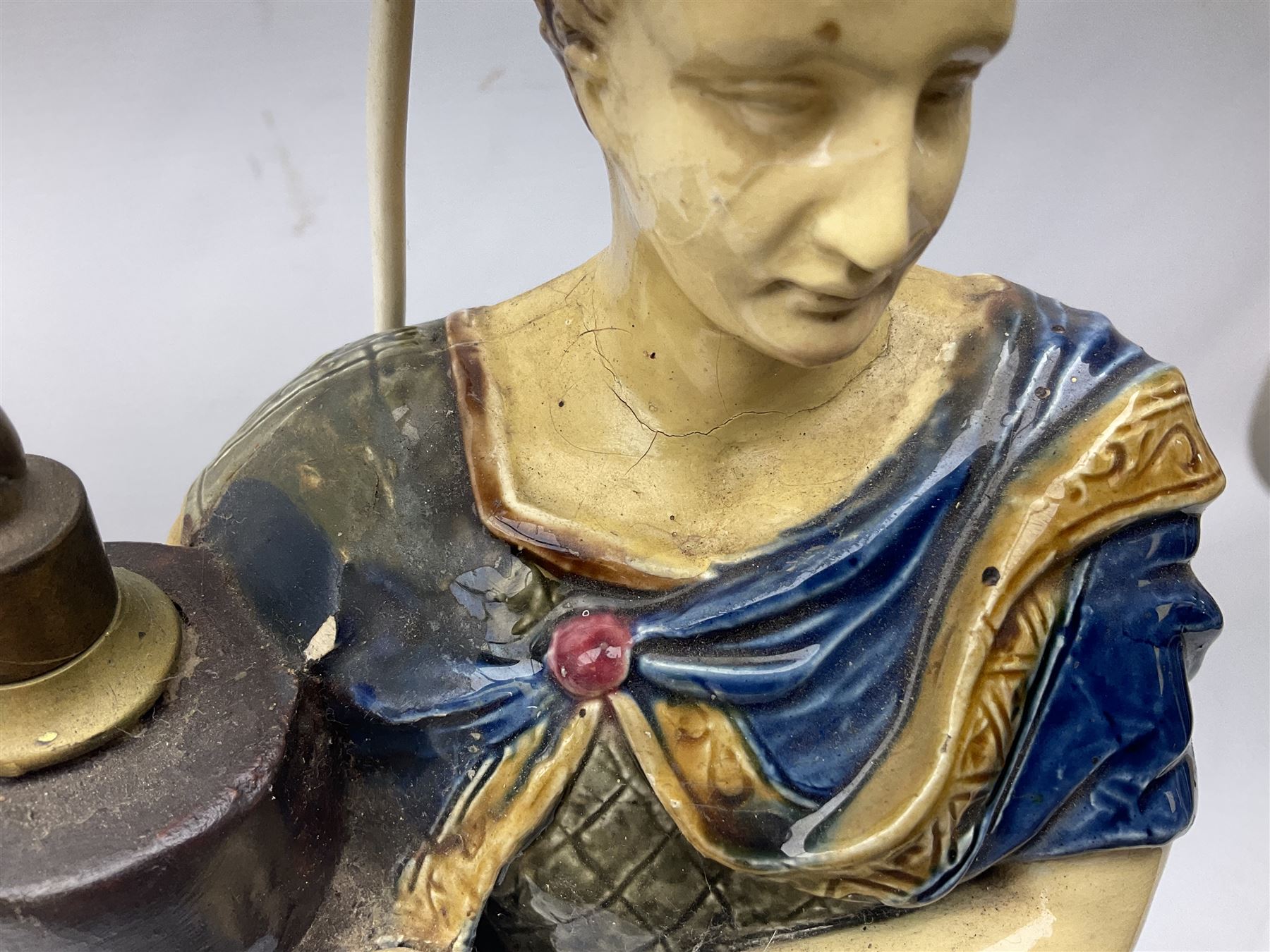 Composite table lamp modelled as a Roman Emperor donning blue robes, upon quatrefoil base modelled with rams heads and winged cherubs, H56cm excl fitting