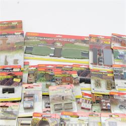 Forty-six Hornby N Gauge Lyddle End model railway trackside buildings and accessories, including N8574 Canal Bridge Adapter and Ramps, N8724 Castle Ruins Walling x 3, N8069 Tractors, N8018 Cotswold Stone Wall and N8096 Low Relief Terrace, all carded