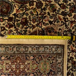 Persian Nain hand-knotted rug, central circular medallion with radiating floral scrolls and palmettes enclosed by ivory field with boteh and foliate motifs, framed by a series of guard stripes and a main border with scrolling arabesques in a midnight blue ground 