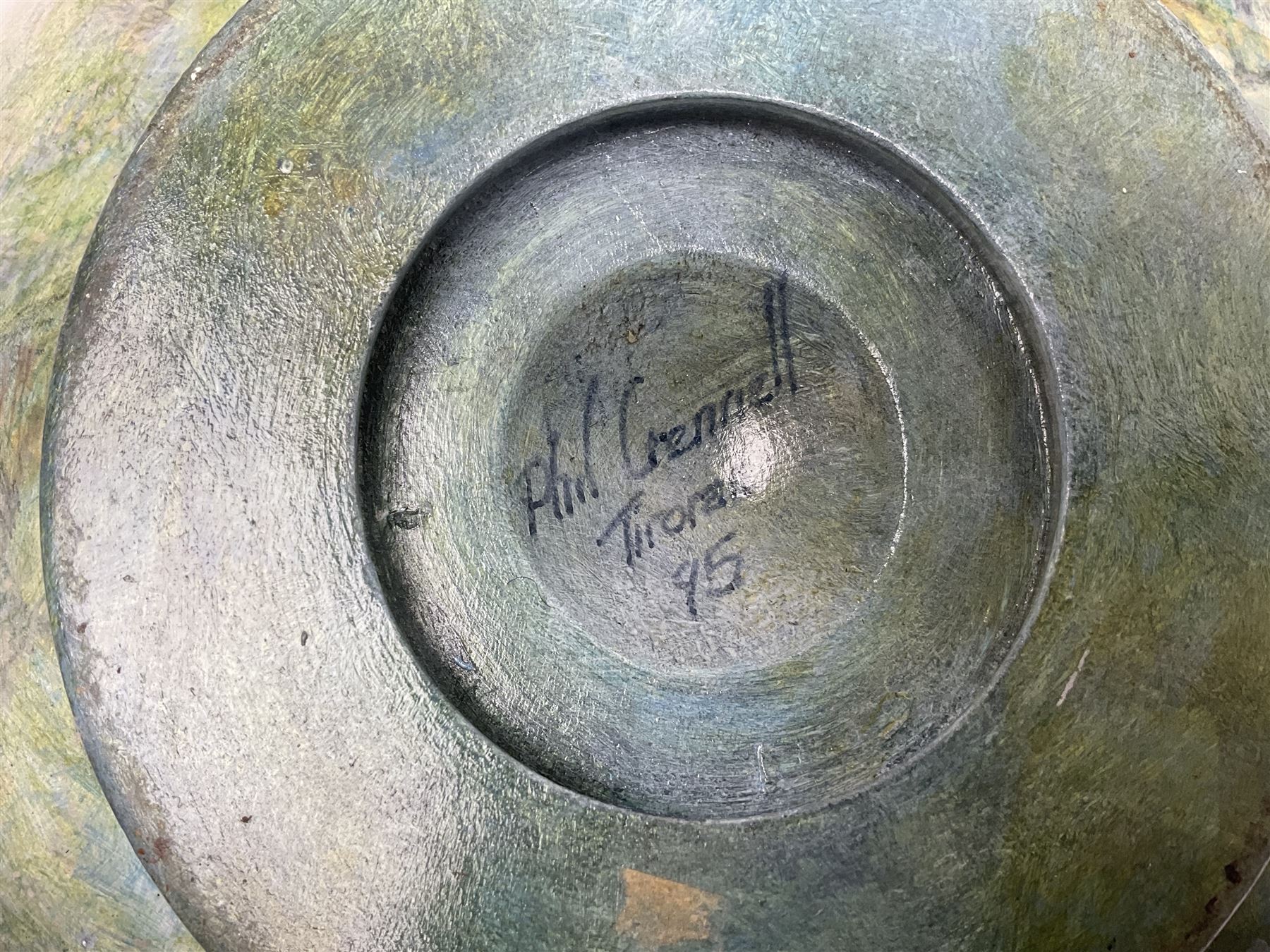 Wooden hand painted bowl, decorated with trees on a blue ground, signed Phil Crennell beneath, D28cm