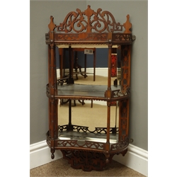  Edwardian walnut wall shelf with mirrored back and two concave shelves with fret work galleries and cresting, turned supports, H72cm, W39cm, D16cm  