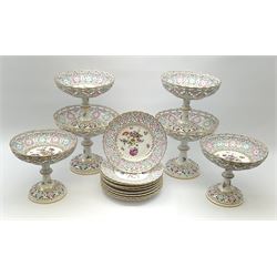 A Dresden dessert service, comprising six comports and nine plates, with pierced rims, and decorated with floral sprays and sprigs and heightened in gilt, tallest comports H20.5cm, plates D22cm.