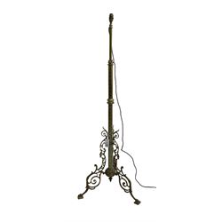 Victorian brass floor standing oil lamp, column decorated with ivy and acanthus leaves, the tripod base pierced with scrolled foliate decoration, with ivory and gilt shade, later converted to electricity