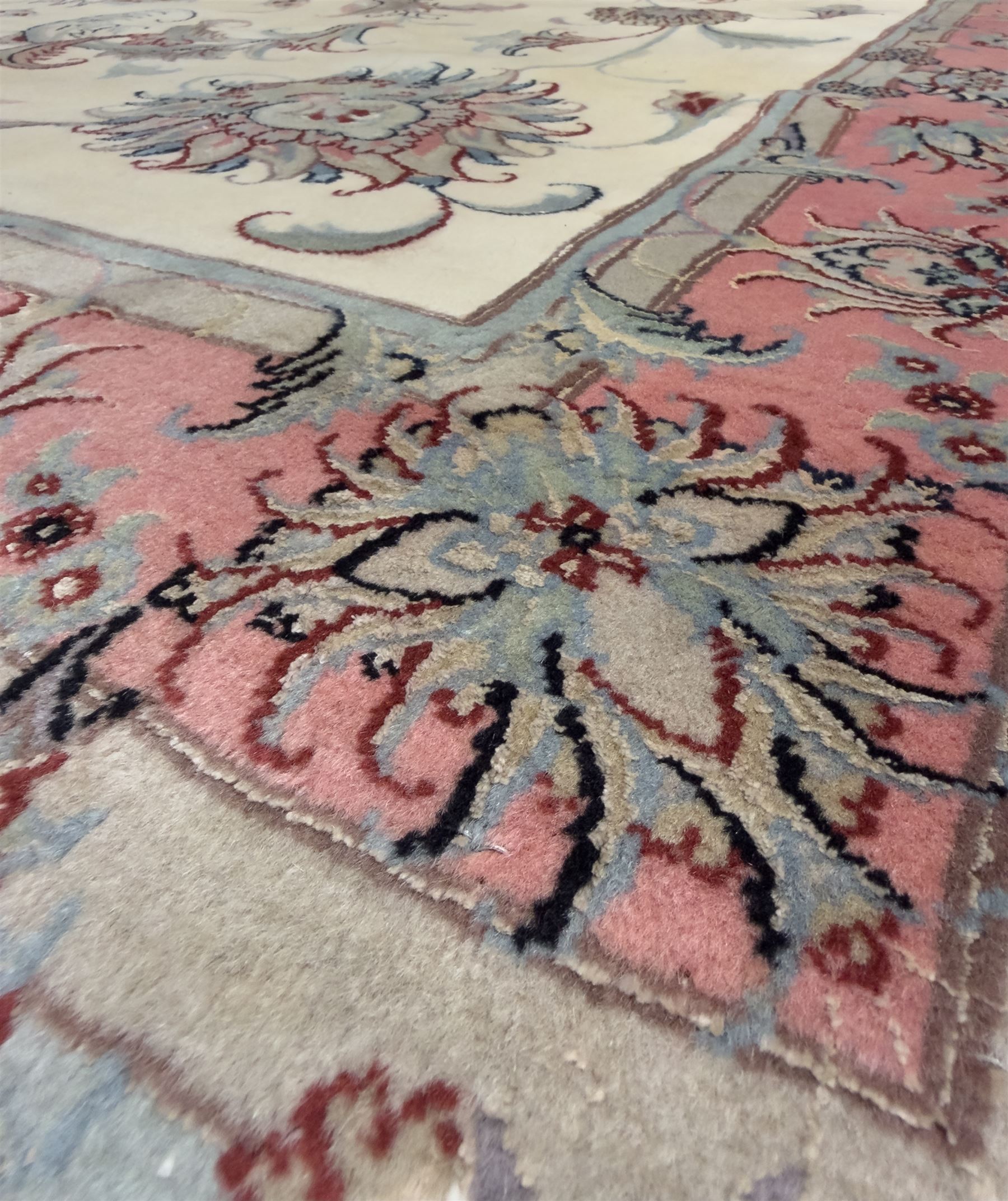 North East Persian Kashmar hand-knotted rug, ivory field with an all-over design of linked floral medallions and scrolling vines with a central circular medallion enclosed by multiple borders and a main broad madder field with palmettes and arabesques, 248cm x 145cm