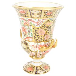 Royal Crown Derby campana vase, decorated in imari pattern, with gilt handled upon a circular base, with mark beneath, H22cm