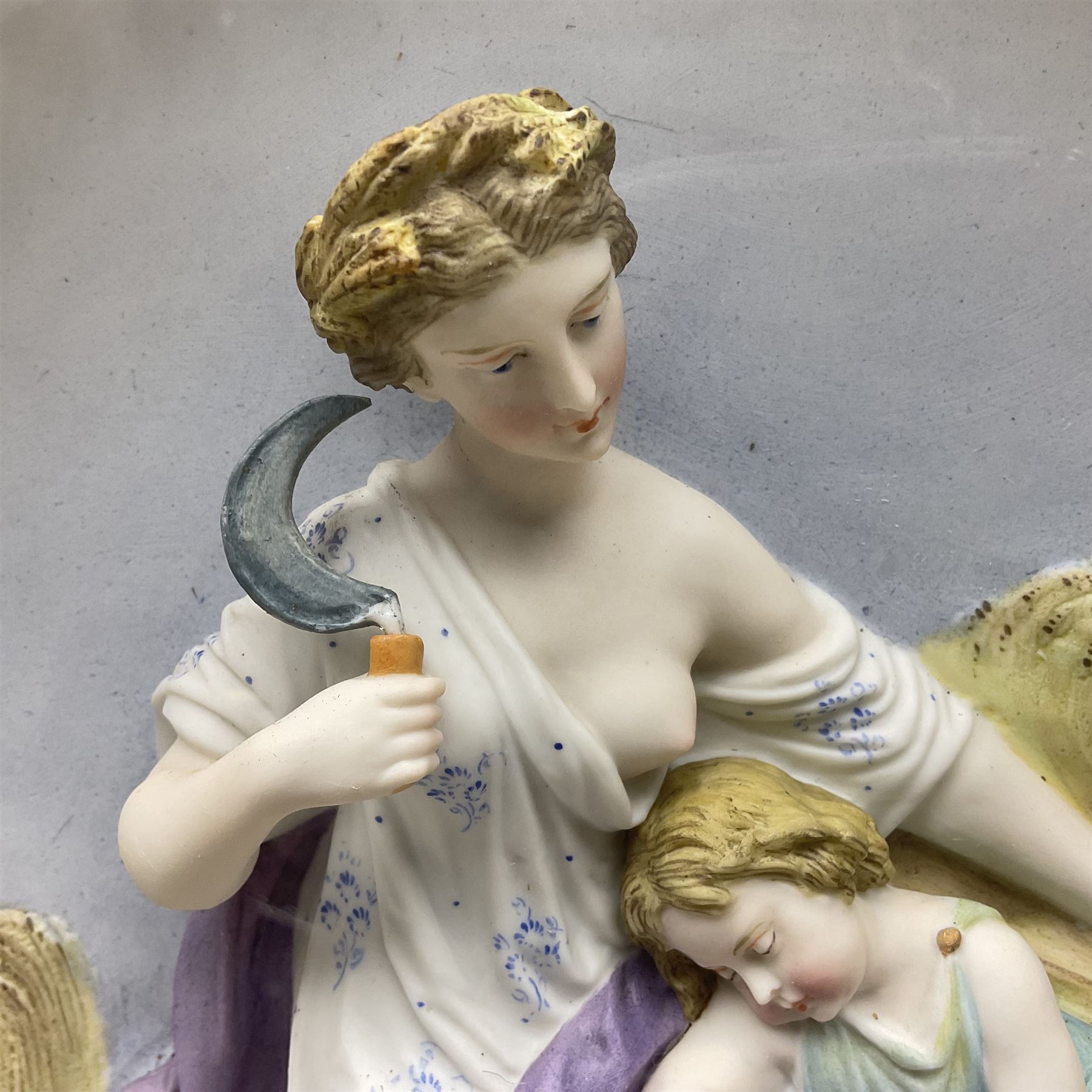 Set of four early 20th century Continental bisque plaques, each of circular form, modelled in high relief as the Four Seasons personified, within gilded circular frames under convex glass, overall D44.5cm