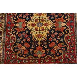 Collection of four Persian rugs, comprising a Saraband ivory ground rug with all-over boteh field and multiple borders; a crimson ground Hamadan type rug with all-over stylised floral and geometric motifs; a floral medallion prayer rug with dark field and ivory spandrels; and a Hamadan peach ground rug with repeating stylised flowering plants and dark multiple borders, largest 83cm x 142cm