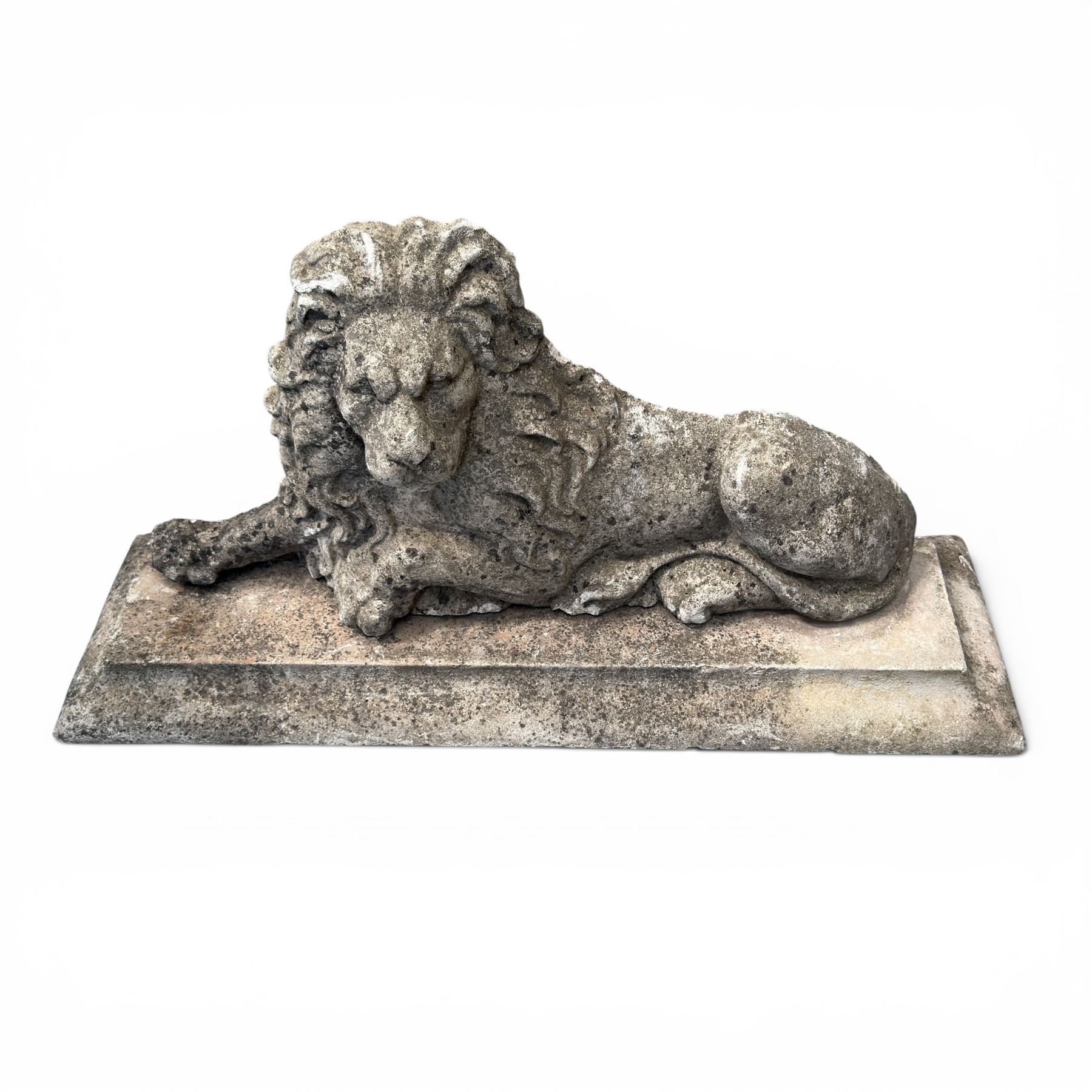 Neoclassical design cast stone garden lion, modelled recumbent with raised and flowing mane, on rectangular plinth base, with flat plain reverse, in weathered finish