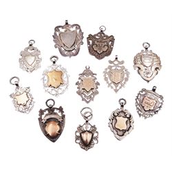Twelve silver cartouche fobs, mostly Victorian and Edwardian examples, to include a gold faced example engraved with domino, hallmarked Chester 1893, a number of other gold facing examples, and three double sided examples, various hallmarks, dates ranging 1894-1919, approximate total weight 4.53 ozt (140.8 grams)