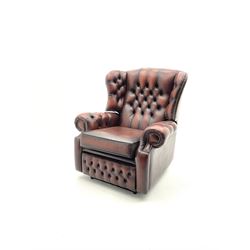 Electric reclining armchair, scrolling arms, upholstered in deep buttoned brown leather