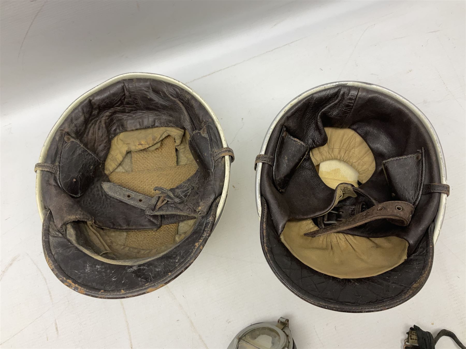 Two Geno Paris small size motorcycle helmets; and three pairs of goggles, one marked 'Stadium'
