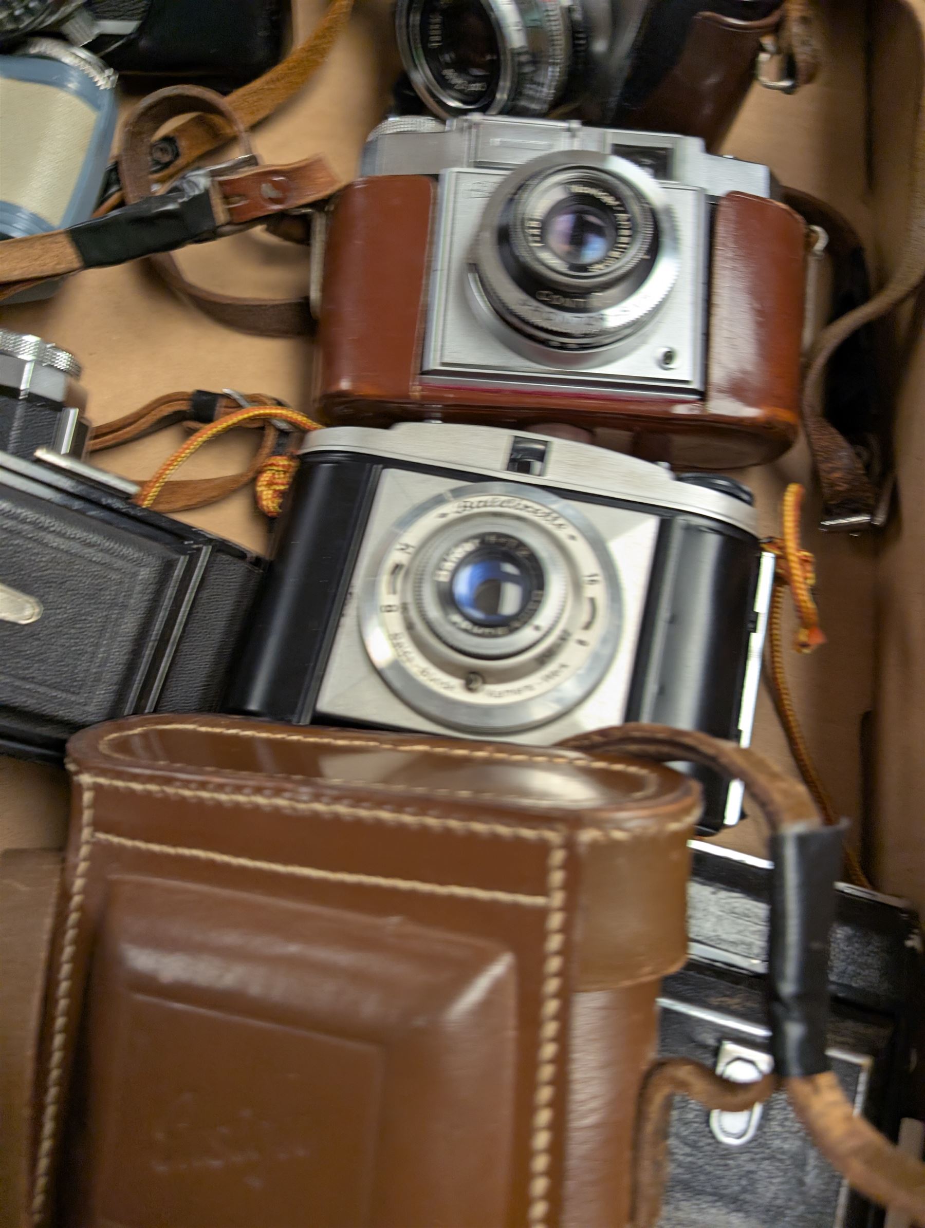 Collection of vintage cameras, including Zeiss Ikon, Canon Canonet, Ensign, etc