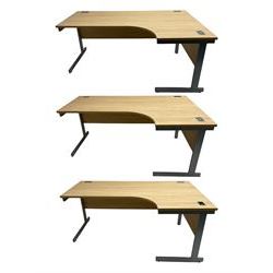 Three light oak finish desks on silver finish supports 
