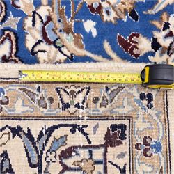 Central Persian Nain hand-knotted rug, soft blue field with central medallion with finely drawn scrolling palmettes and floral tendrils, with ivory spandrels, enclosed by a floral meander border flanked by multiple guard stripes with cotton fringe ends 