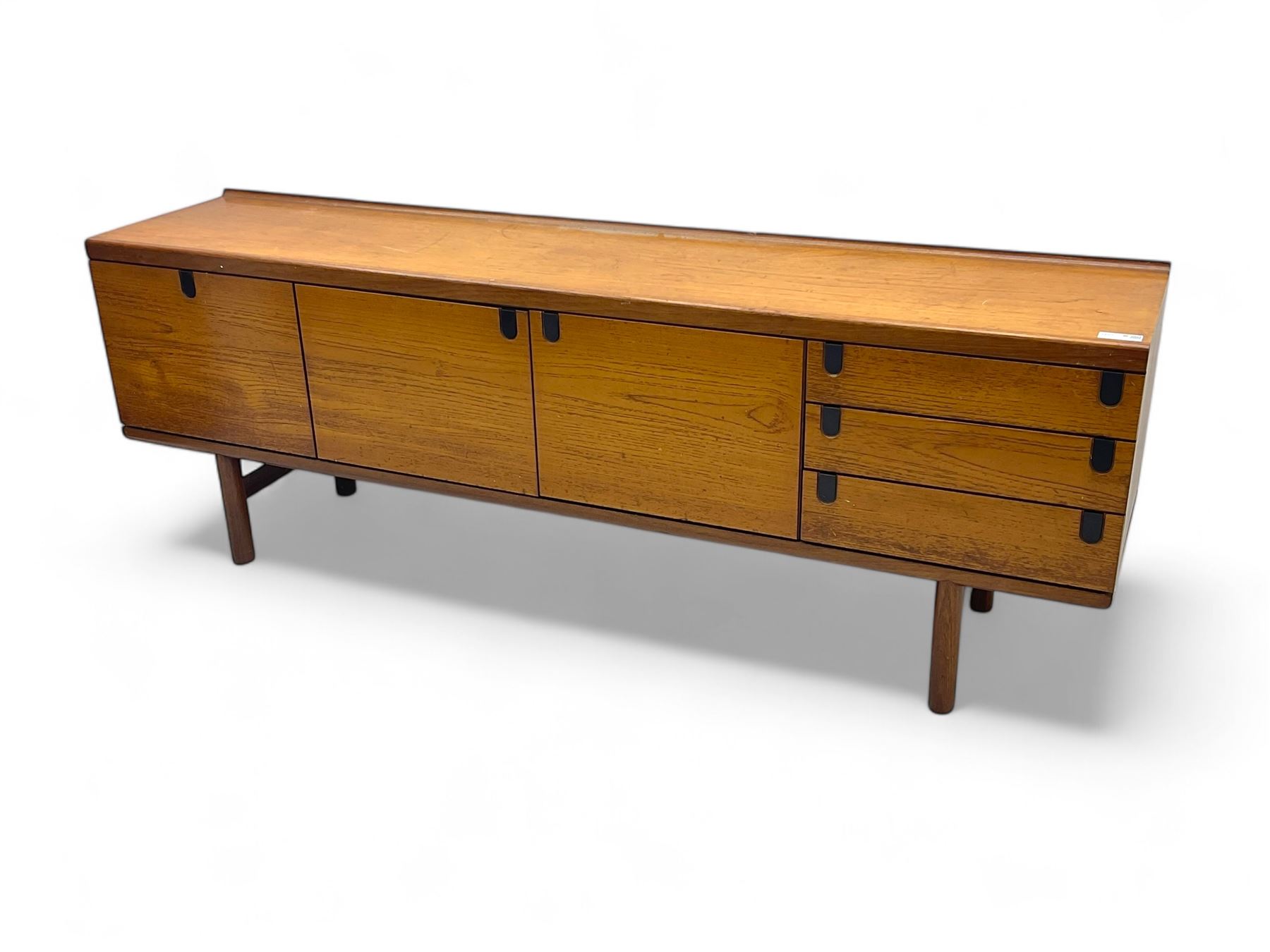 White & Newton - mid-20th century teak sideboard, rectangular top with raised back over fall-front storage compartment, double cupboard and three drawers, raised on cylindrical supports