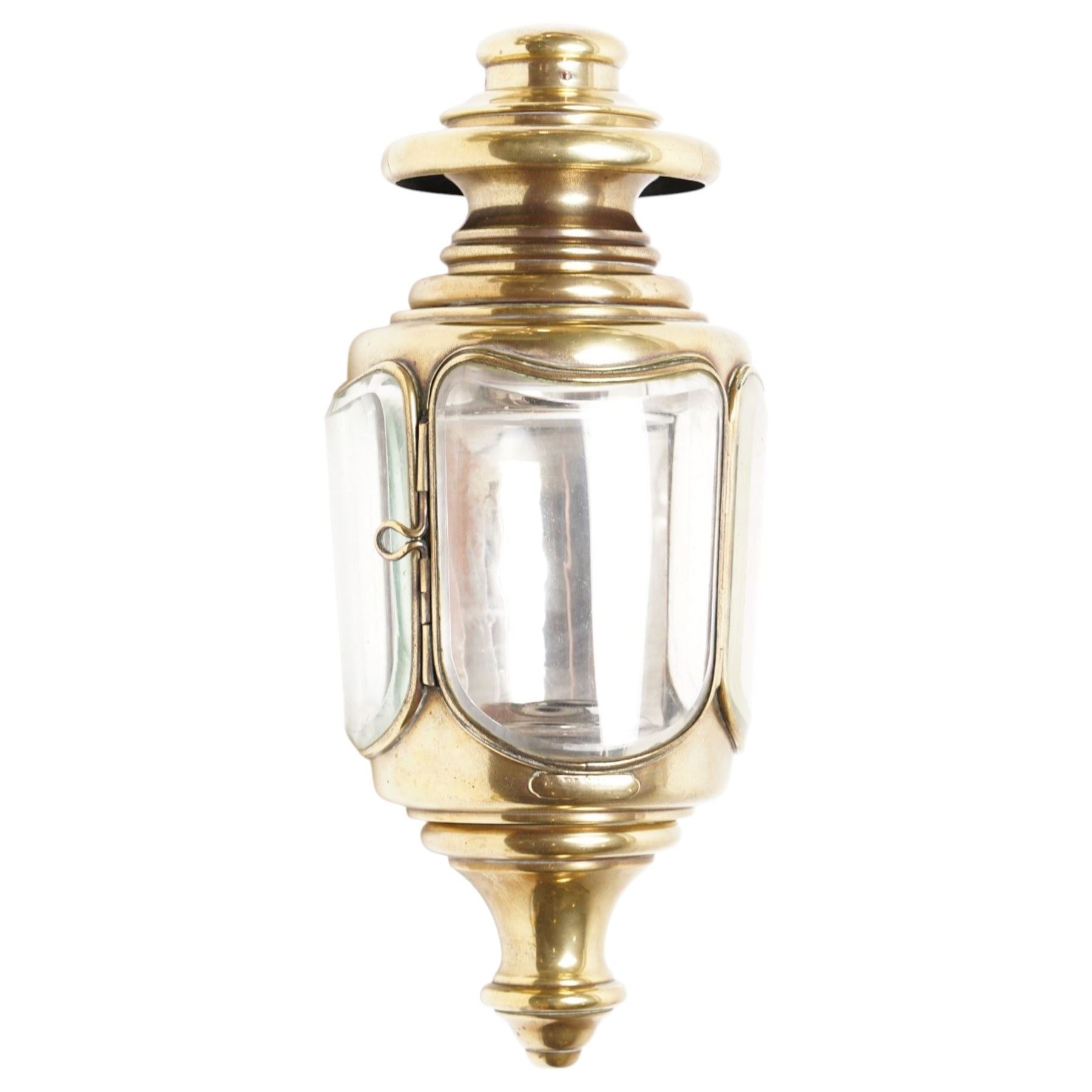 Bleriot Ltd. (London) - pair of Edwardian brass carriage lamps no.152, the body with three faceted bevelled glass panels, surmounted by brass chimney, the back mount with makers plaque below
