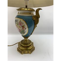Sevres style table lamp, the ovoid body with twin gilt metal handles, hand painted with a gilt framed panel of cherubs to one side, and flowers to the other, against a bleu celeste type ground, upon a gilt metal socle and plinth base, with cream fabric shade, lamp H39cm