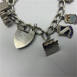Hallmarked silver bracelet with heart shaped clasp, set with various mostly silver charms including 'Whitby' and 'York' etc