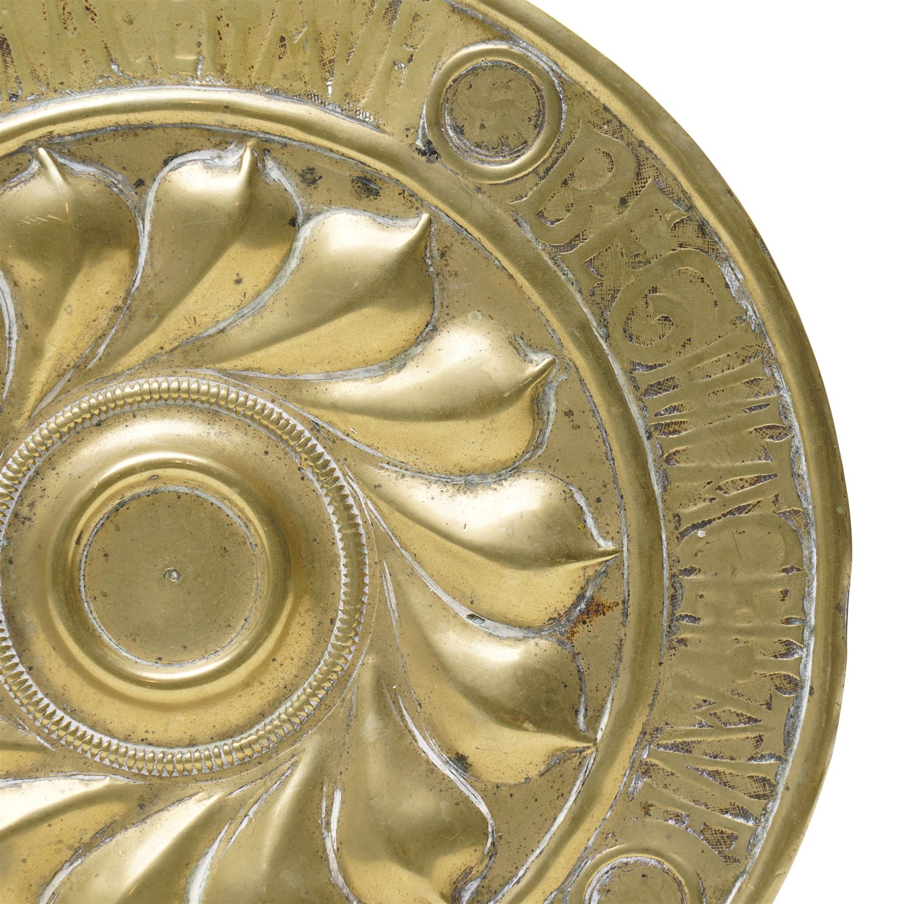 Central section of a 17th century Nuremberg brass alms dish, central rosette surrounded by Gothic inscription, intersected by roundels with engraved heads, D23cm 