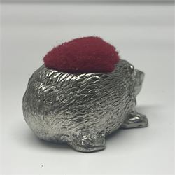 Egyptian silver lidded box, two continental silver thimbles and three others, cast metal hedgehog pin cushion and a rectangular trinket box