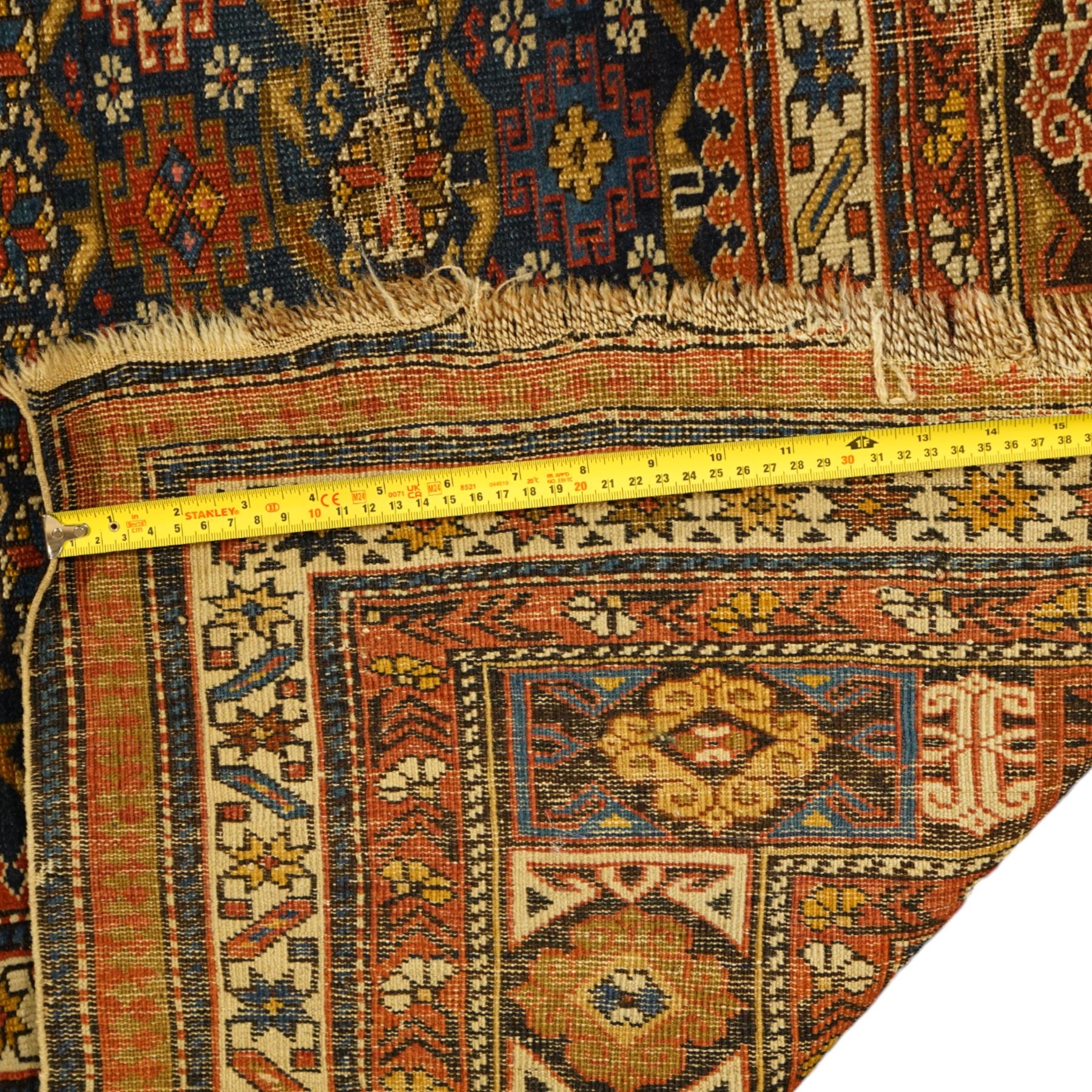 Two antique Caucasian Shirvan rugs, indigo field decorated with horizontal bands of small geometric floral and star motifs within multiple finely drawn borders featuring diamonds, rosettes, and stylized leaves in a palette of madder red, ivory, ochre, and pale blue, with fringe ends, 195x137cm, together with a similar smaller rug, 143x96cm