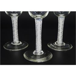 Set of three 18th century drinking glasses, the rounded bowls upon double series opaque twist stems and circular feet, H11cm