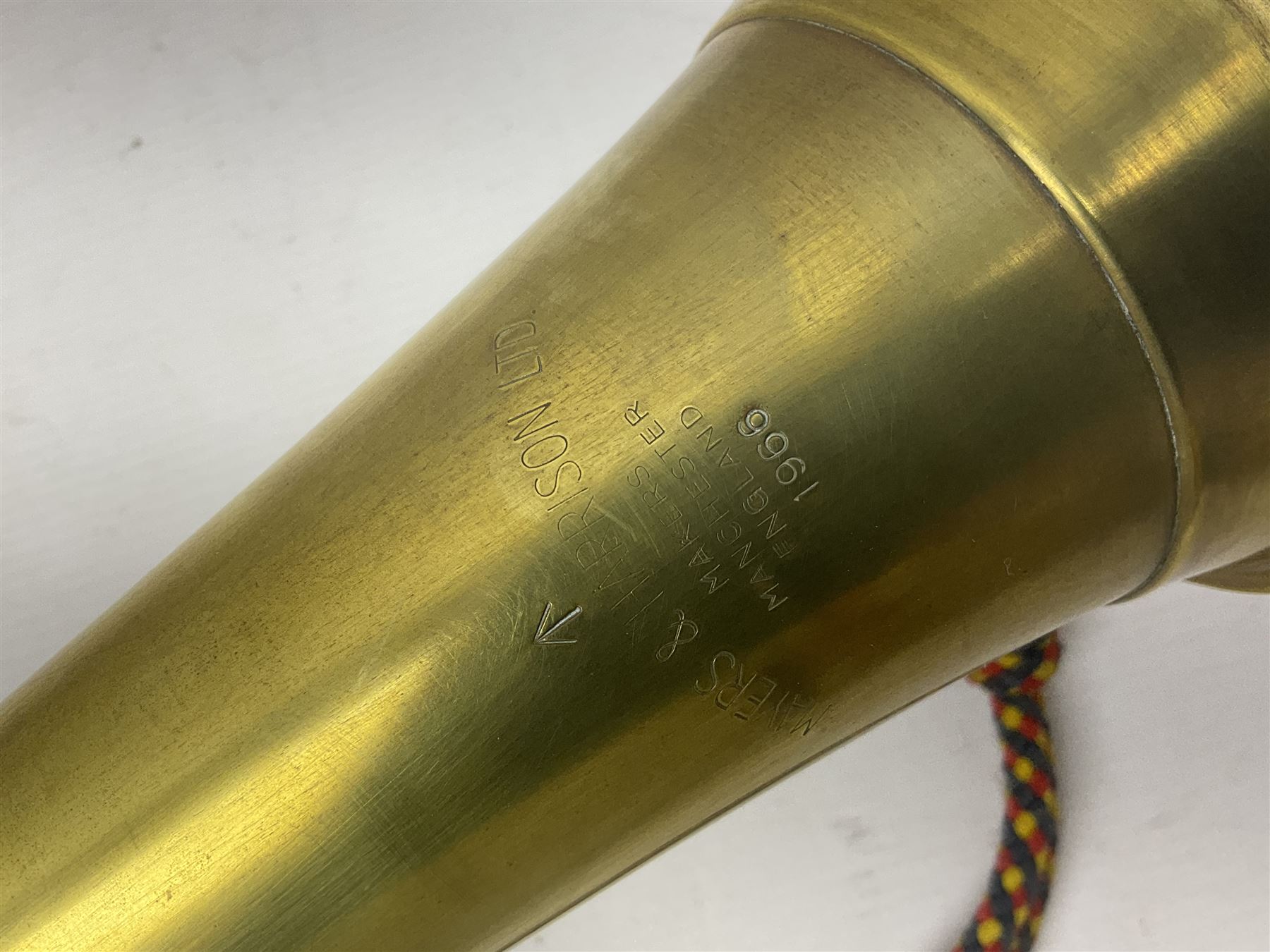 Two military brass bugles by Mayers and Harrison Ltd. Manchester each with crows foot mark and dated 1966; both with multi-coloured cord and tassels, longest 52.5cm (2)