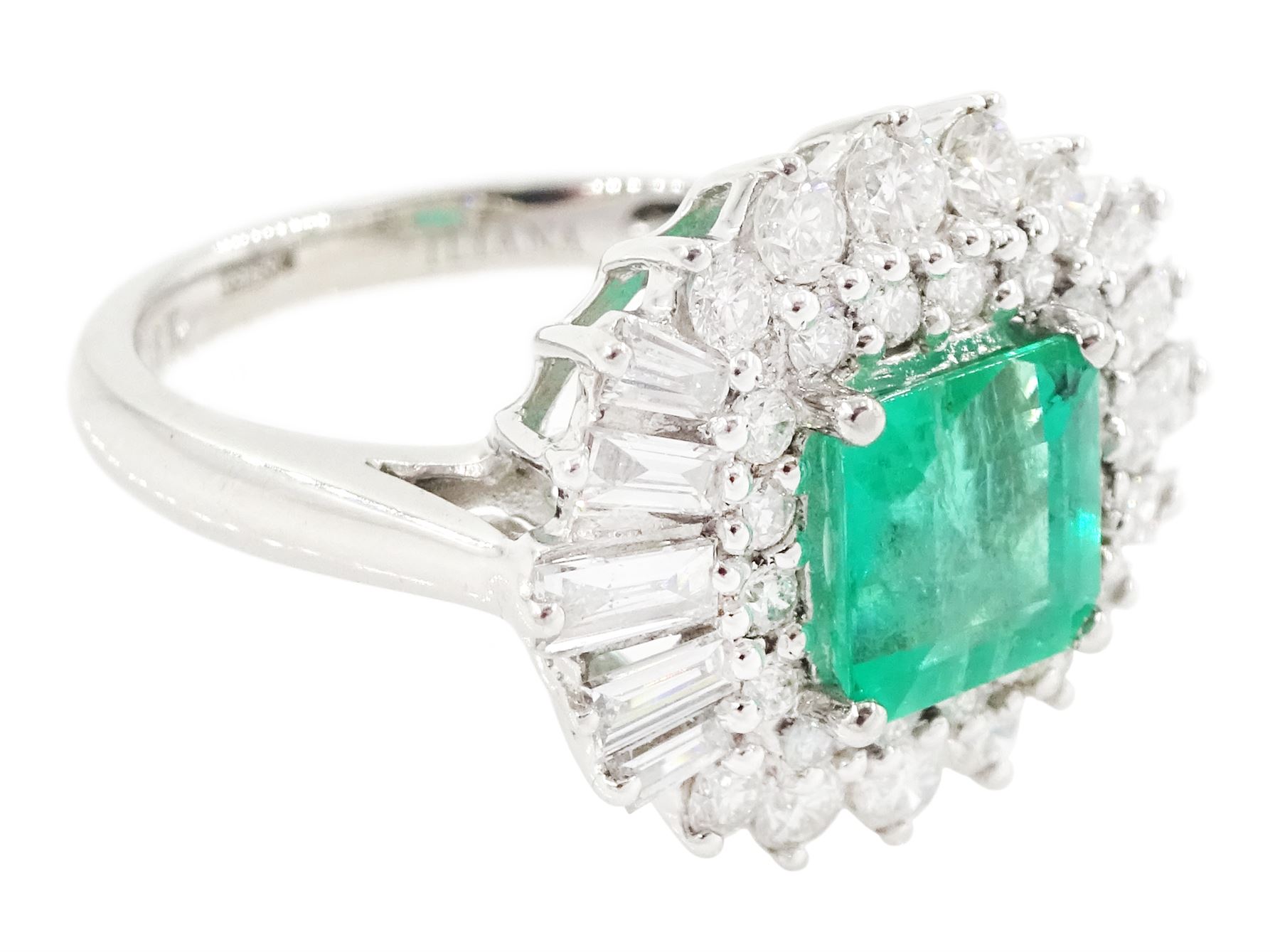 18ct white gold Colombian emerald and diamond cluster ring by Iliana, single octagonal cut emerald of 1.65 carat, surrounded by two rows of round brilliant cut and tapered baguette cut diamonds, hallmarked