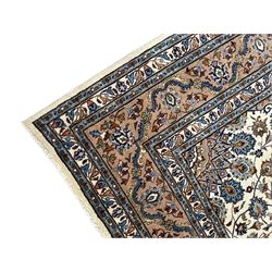 Persian Kashan ivory ground rug, the central medallion surrounded by an arrangement of palmettes united by scrolling leafy branches, peach ground main border decorated with trailing leaf and stylised plant motifs, floral pattern guard stripes 