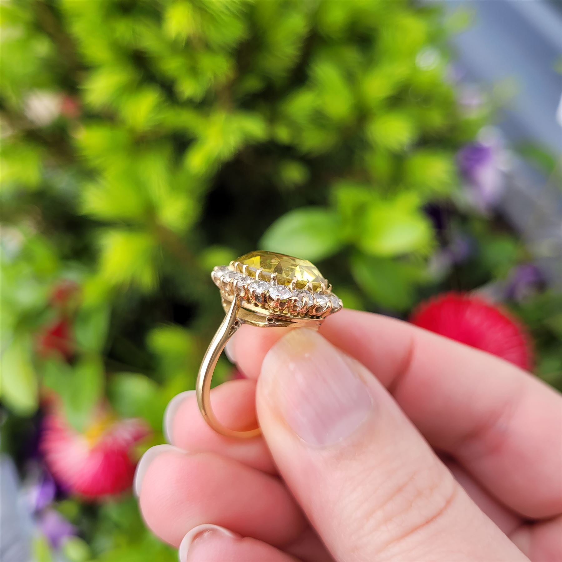 Early 20th century gold chrysoberyl and diamond cluster ring, single cushion cut yellow / green chrysoberyl of approx 8.00 carat, surrounded by sixteen old cut diamonds, stamped 18ct, total diamond weight approx 1.10 carat