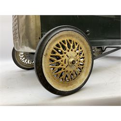 Mid 20th century pressed steel pedal car, the body painted in dark green fitted with pretend radiator to the bonnet, with spoked wheels and rubber tyres, the interior with pedals and steering wheel, L70cm