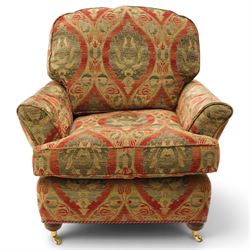 Duresta - traditional shape armchair with out-swept arms, upholstered in crimson ground fabric decorated with palmettes and foliate motifs with matching loose and scatter cushions, raised on compressed bun feet with brass cups and castors