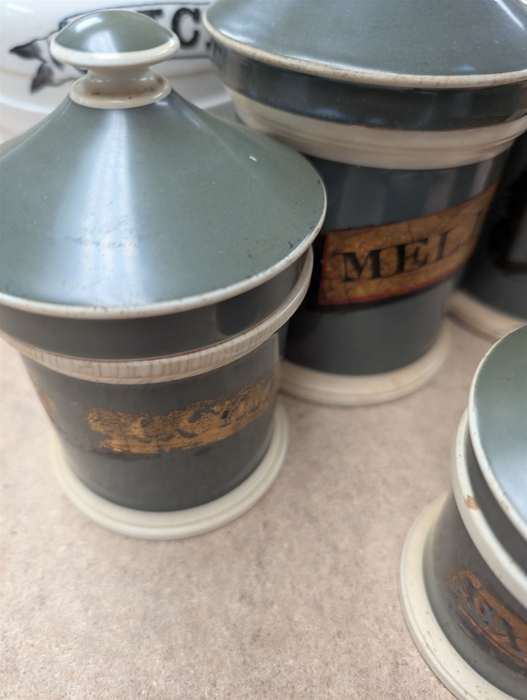 19th century sage green apothecary jars with gilt labels, four white ceramic kitchen jars and a stoneware flaggon marked Wheat Wine