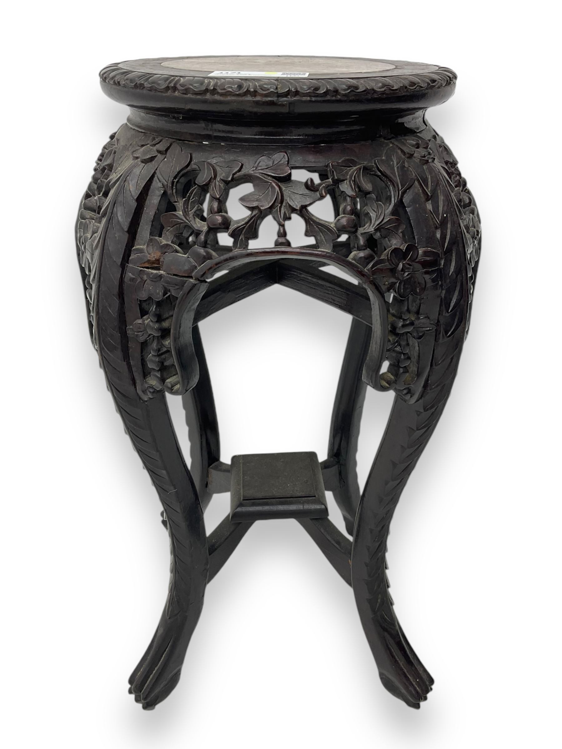 Late 19th century Chinese hardwood pedestal stand, circular top with inset marble panel, carved apron with openwork foliate and floral motifs, raised on cabriole supports with stylised claw and ball feet united by square undertier